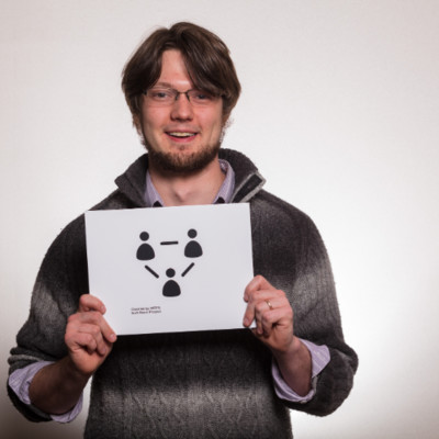 Color photograph of Alex Stinson holding up a sign.