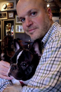 Color photograph of Alex Benchimol holding his dog.
