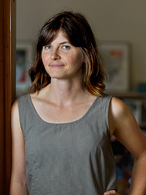 Color photograph of Anastasia Eccles leaning against a wooden doorway.