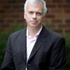 Color photograph of John O'Brien in a suit jacket and button-down shirt.