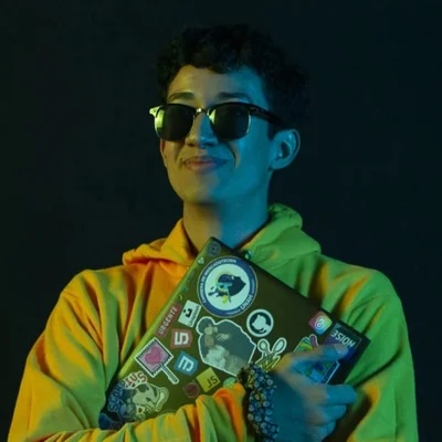 Color photograph of Alex McCarthy holding a laptop. 