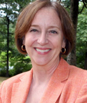 Color headshot of Catherine Ross in a salmon-colored suit. 