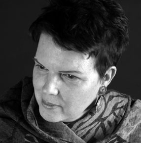 Black and white headshot of Anne Marie Macari wearing a scarf.