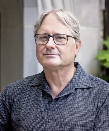 Color photograph of Alan Richardson in a collared polo and glasses.